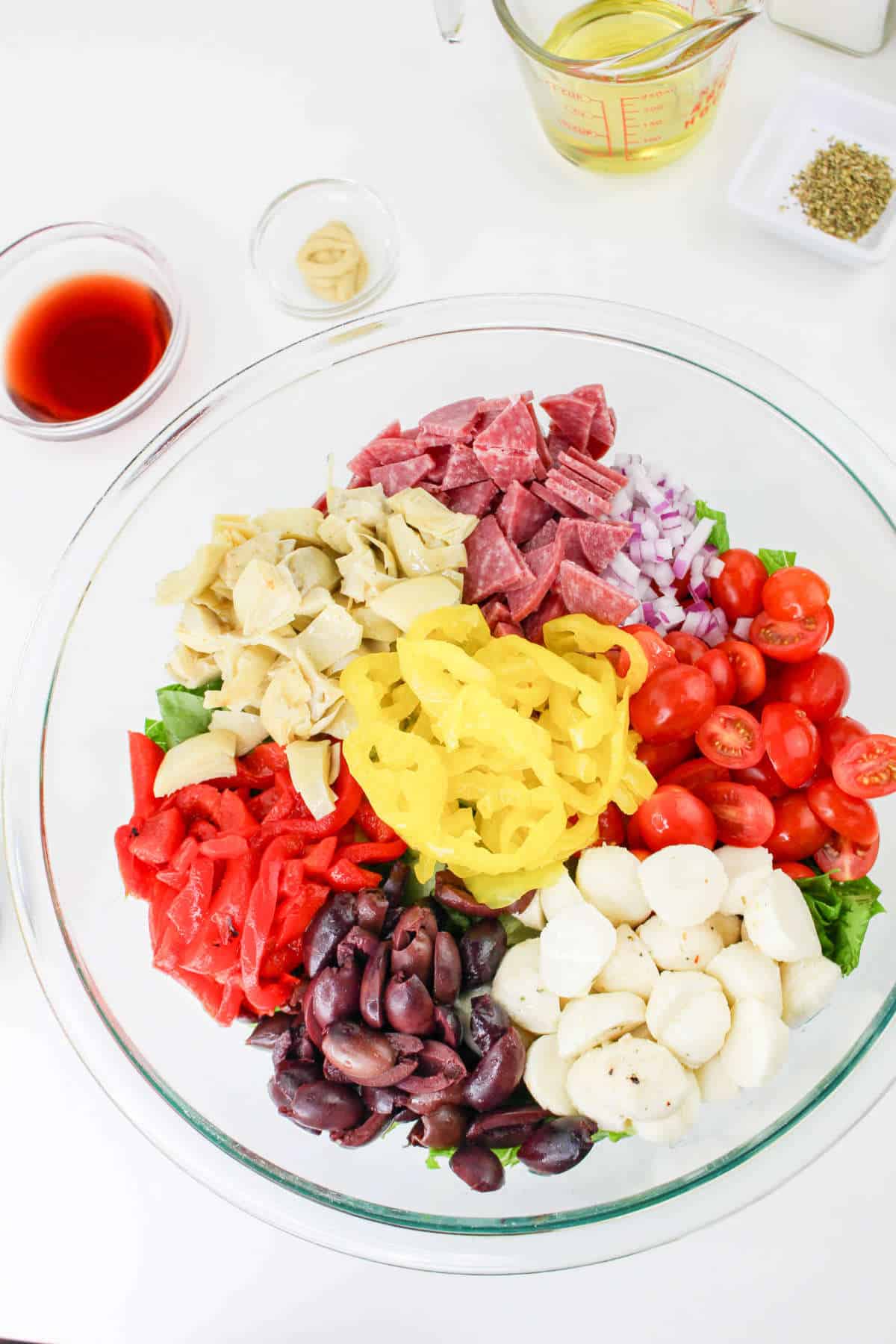 chopped ingredients in a bowl on top of cut romaine lettuce.