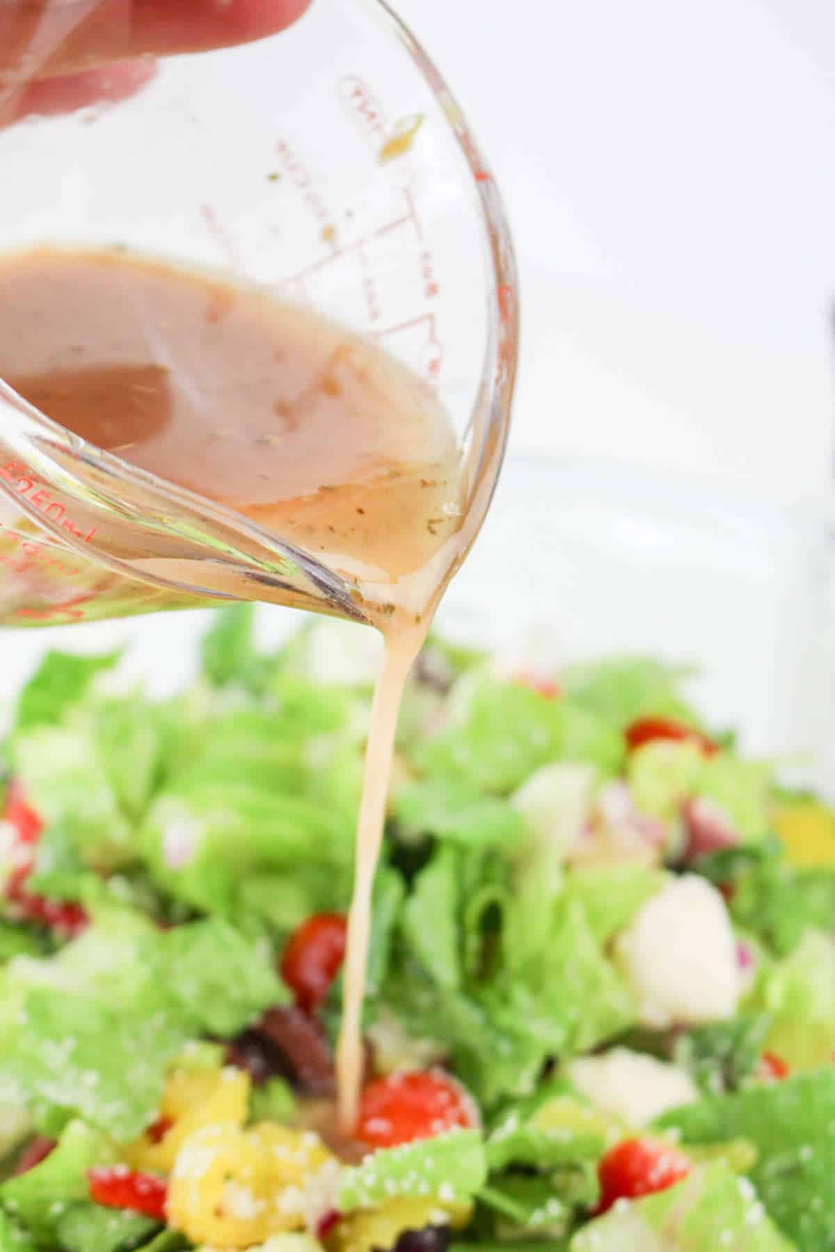 Italian salad dressing poured over a salad.