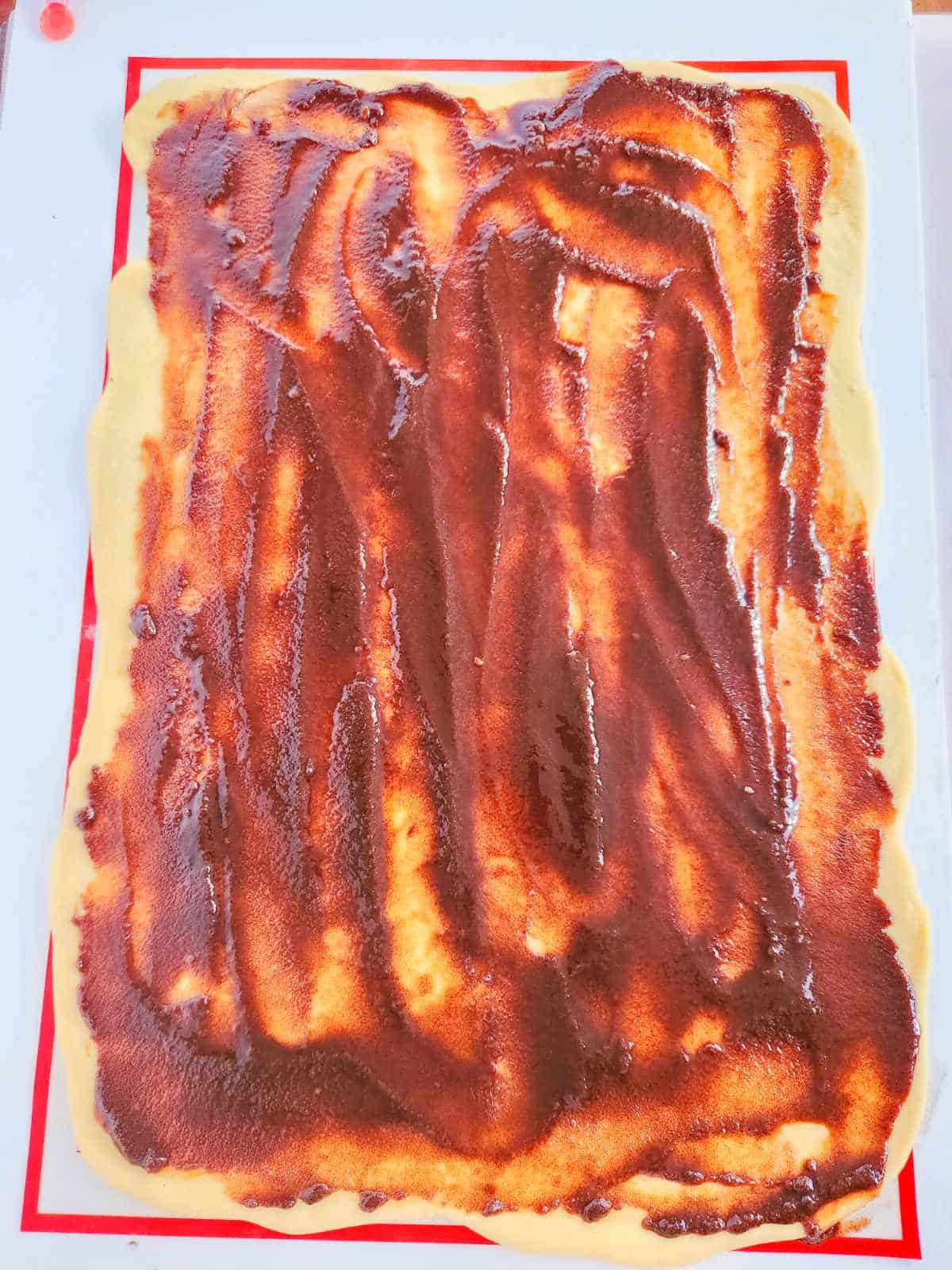 spreading cinnamon filling on rectangle of dough.