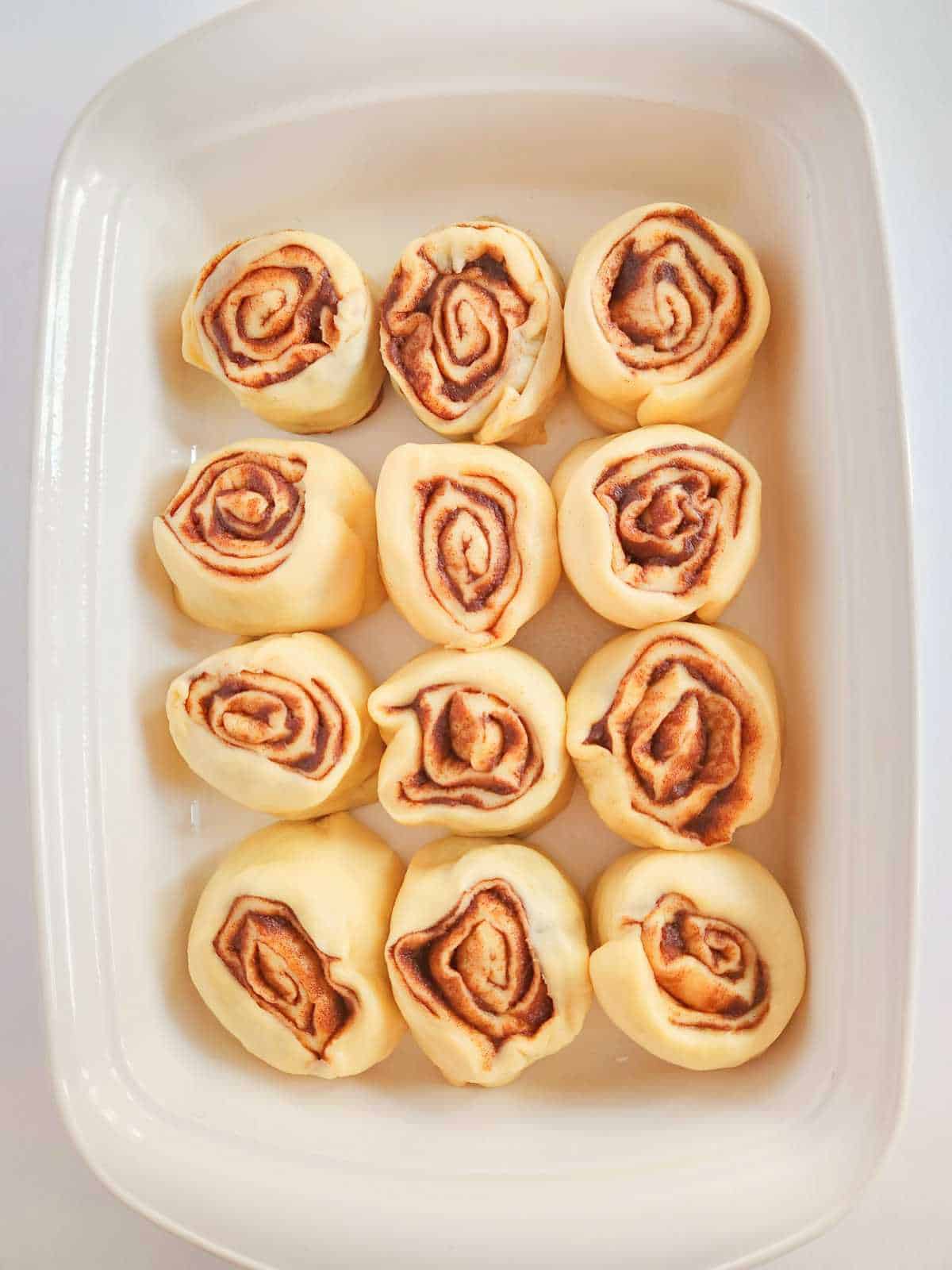 sliced cinnamon rolls in a baking dish.