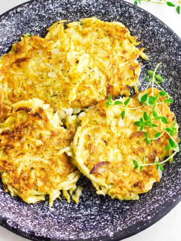 celery root latkes, low carb latkes, with sour cream on a serving platter.