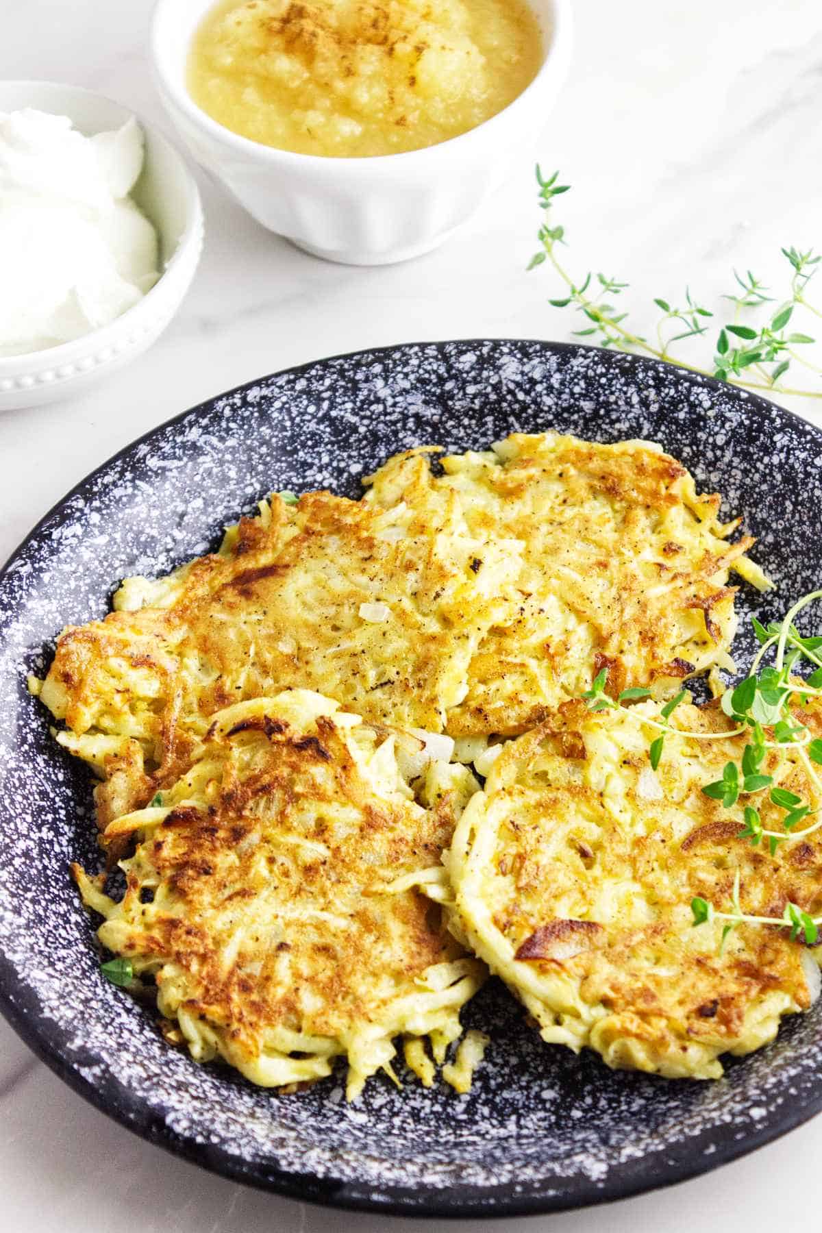 celery root latkes, low carb latkes, with sour cream on a serving platter.