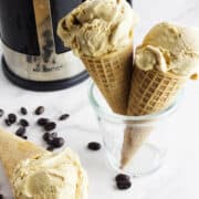 homemade coffee ice cream in cones with a French press in the background.