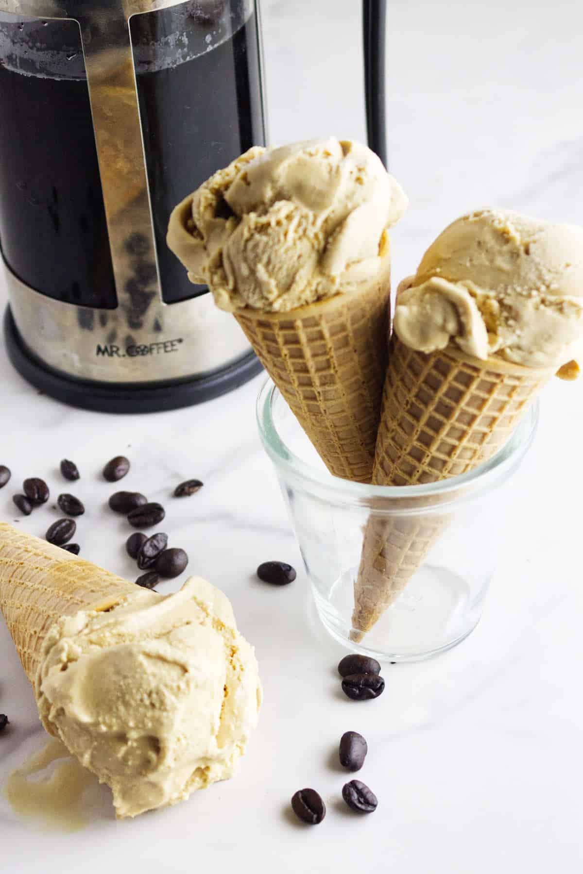 homemade coffee ice cream in cones with a French press in the background.