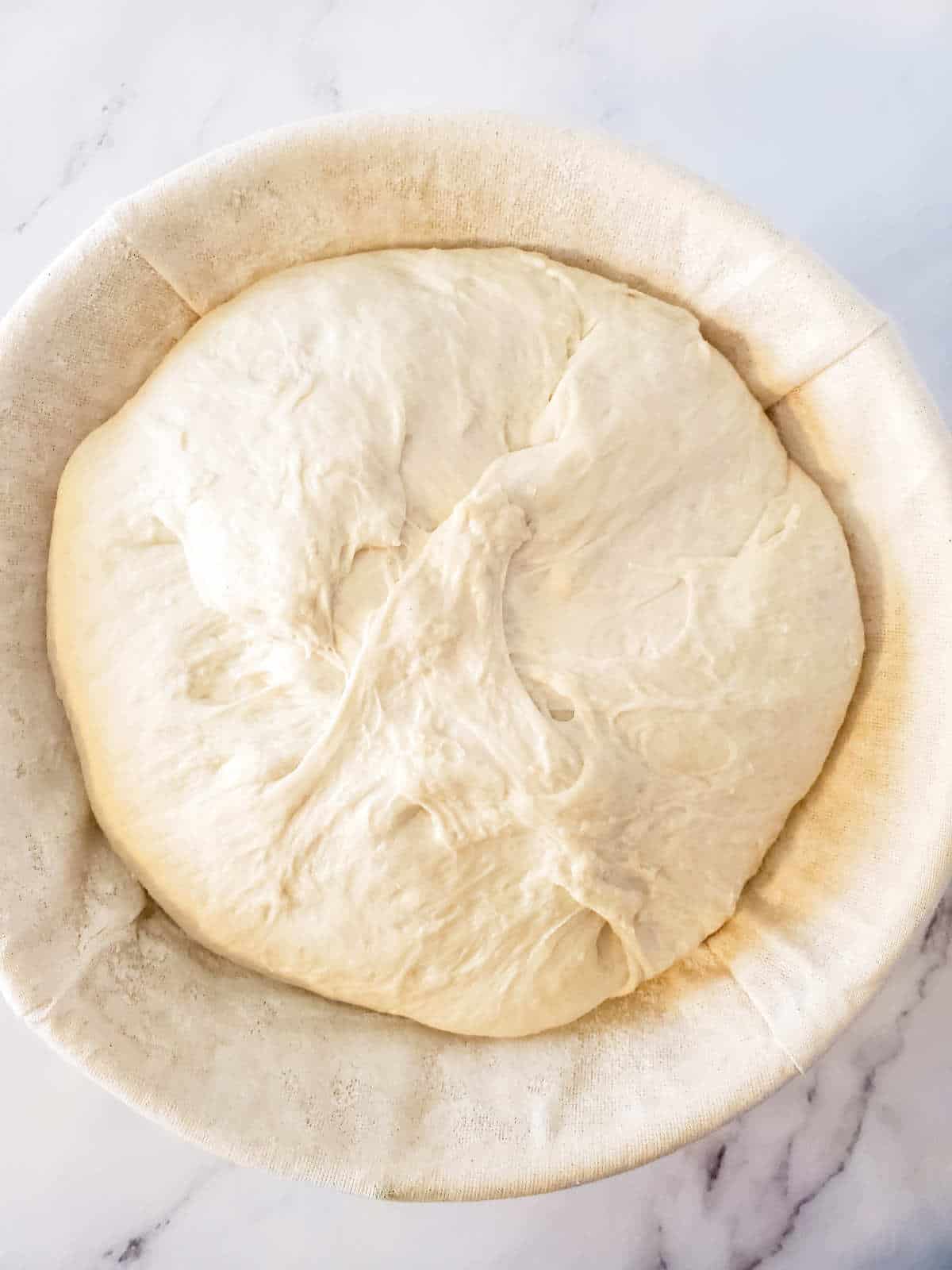 bread dough rising in a banneton.