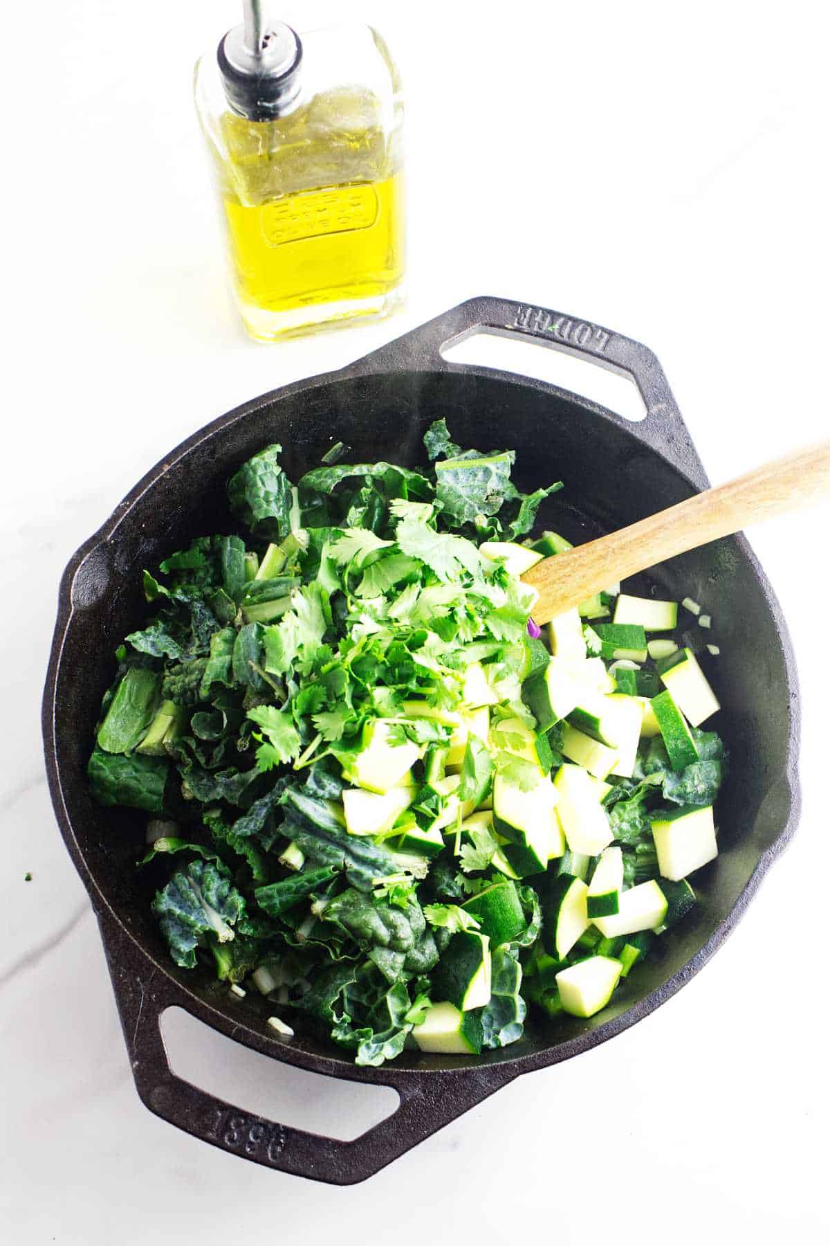 chopped poblano, kale, and zucchini cooking in a skillet.