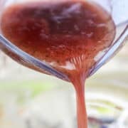 Red wine Italian vinaigrette being poured over salad.
