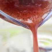 Red wine Italian vinaigrette being poured over salad.