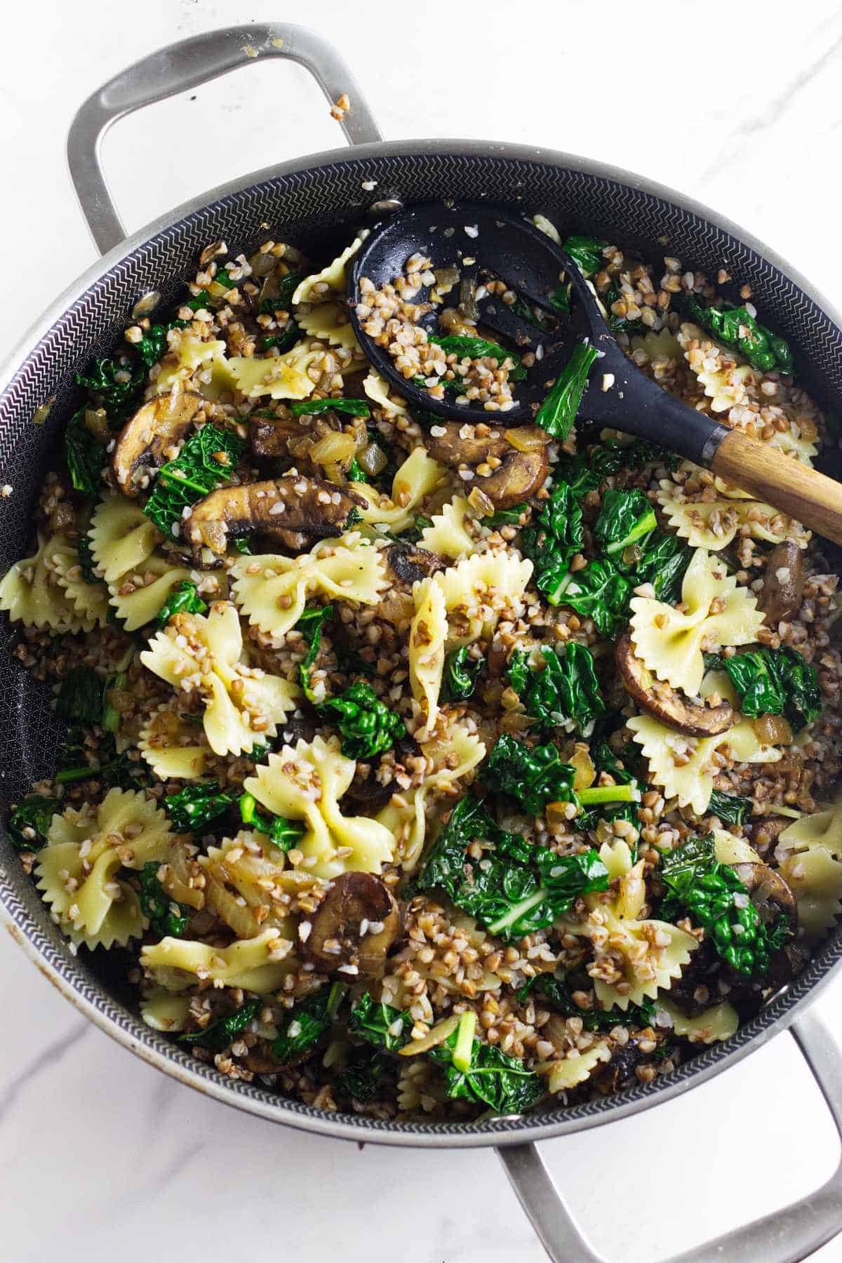 serving bowl of kasha varnishkes with mushrooms and kale.