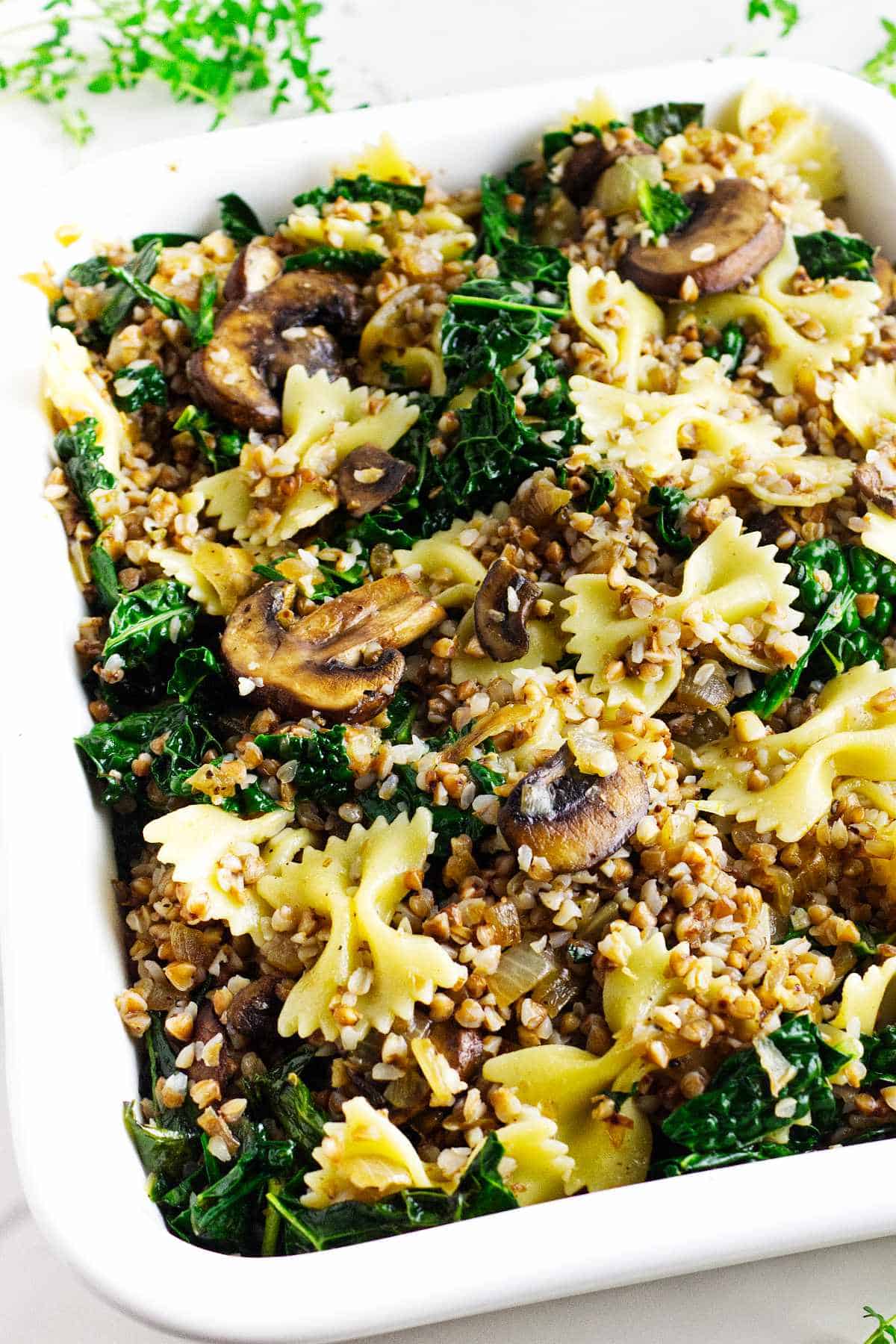 serving bowl of kasha varnishkes with mushrooms and kale.