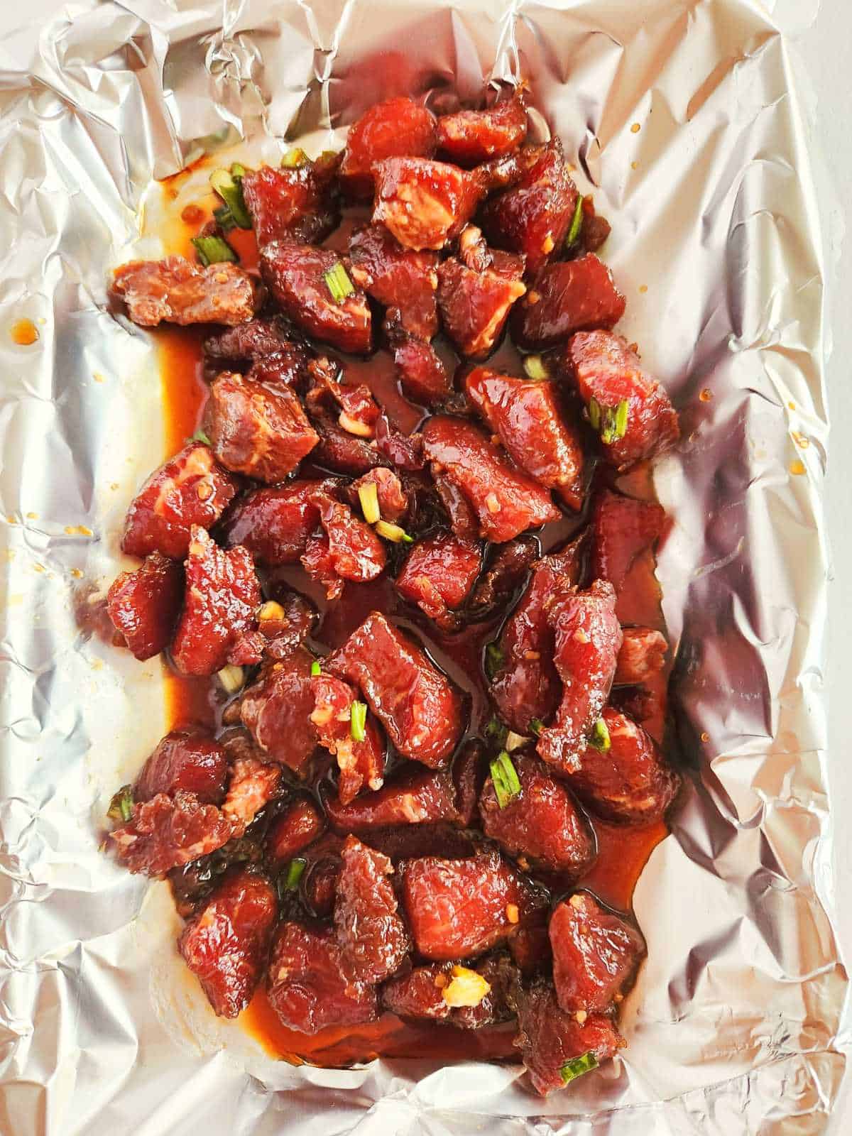 marinated beef on the grill cooking in Korean bulgogi sauce.
