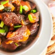 bowl of Korean beef bulgogi with Japanese yum yum sauce drizzled on top.