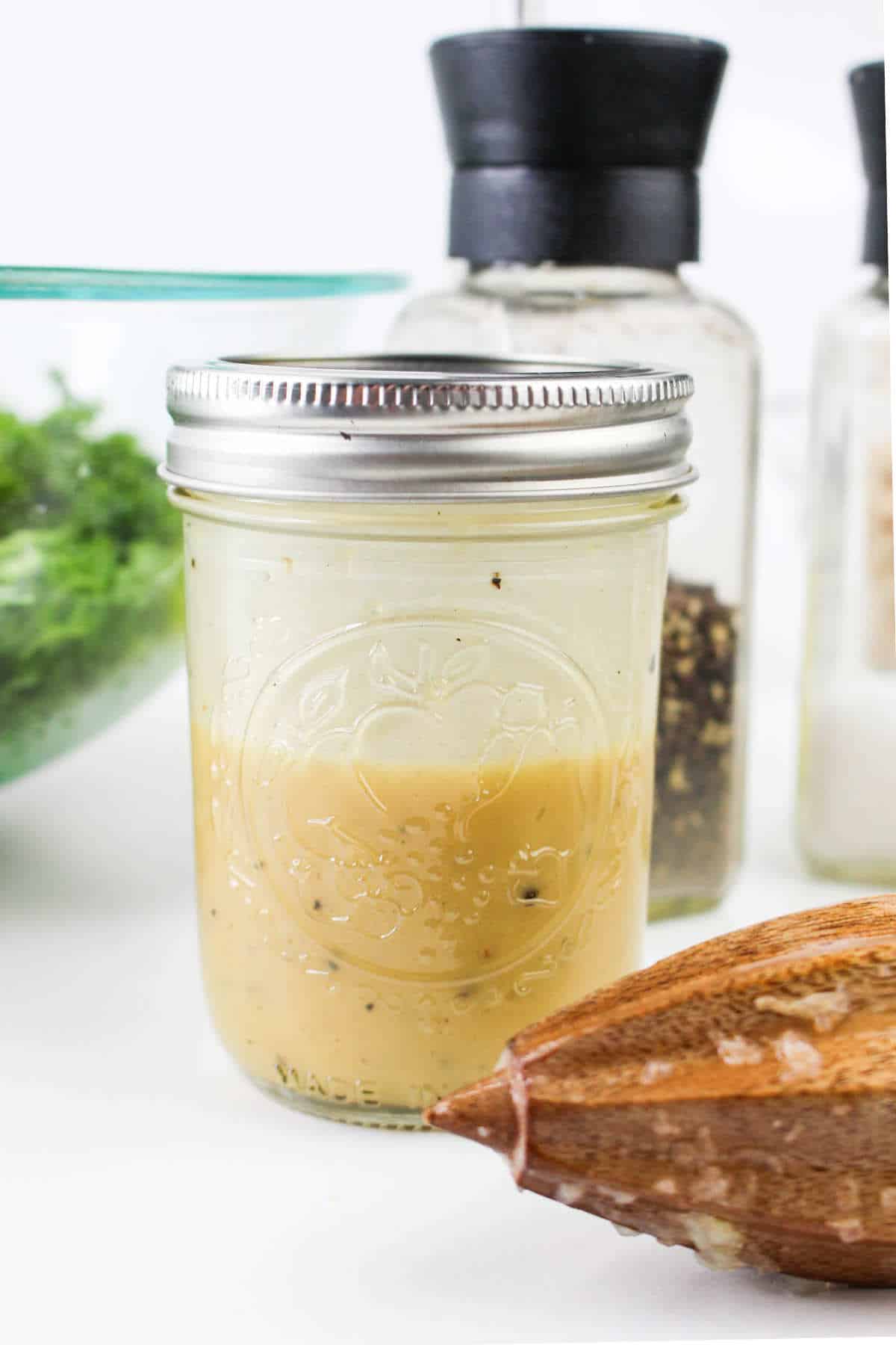 Lemon maple mustard vinaigrette mixed in a Mason jar.