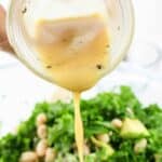 vinaigrette dressing being drizzled on a salad.