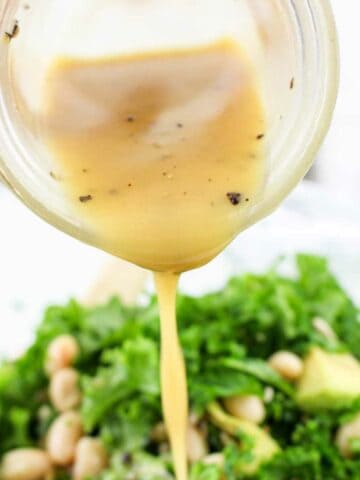 vinaigrette dressing being drizzled on a salad.