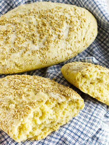 a full and a split loaf of semolina bread on a dish cloth.