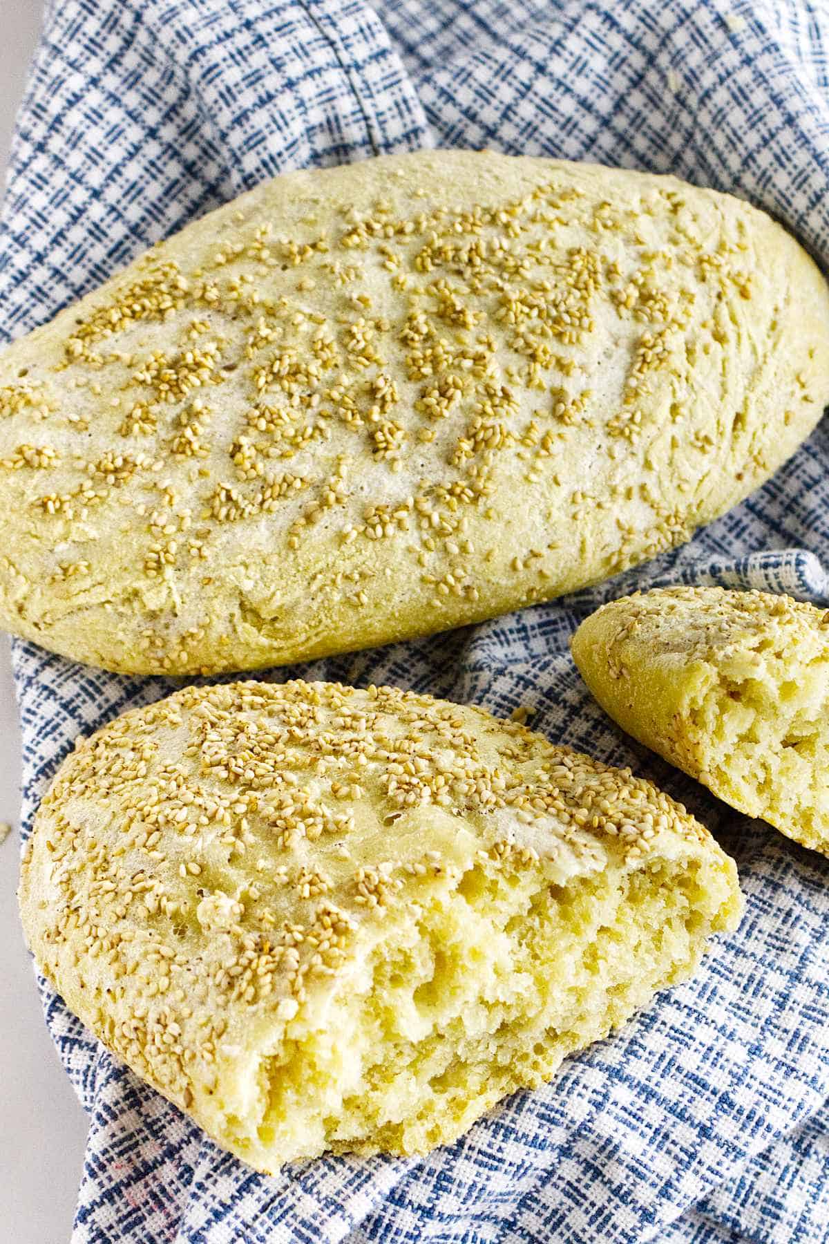 a full and a split loaf of semolina bread on a dish cloth.