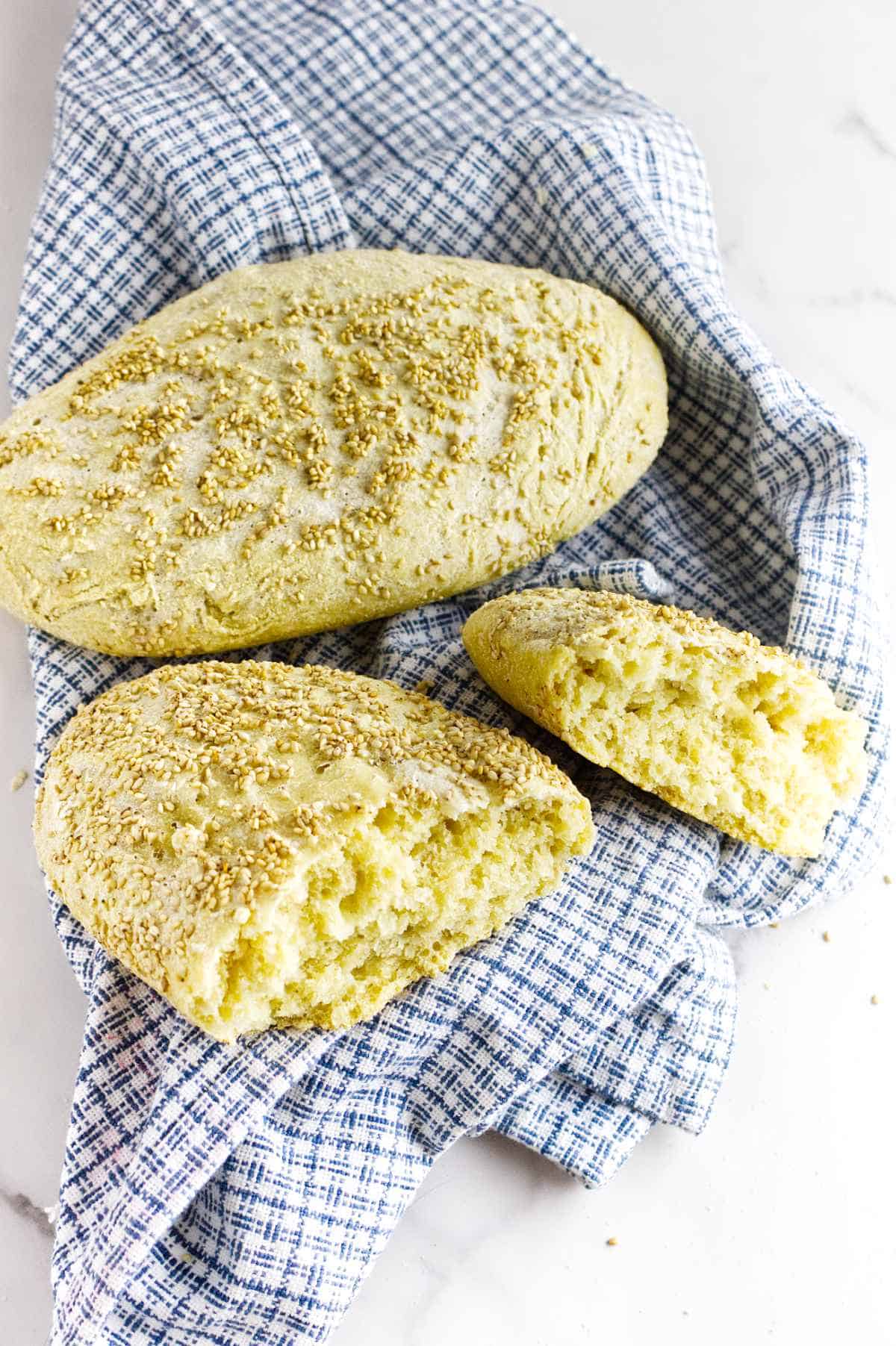 a full and a split loaf of semolina bread on a dish cloth.