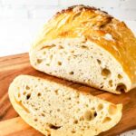 Slice of sourdough bread on a wooden cutting board.