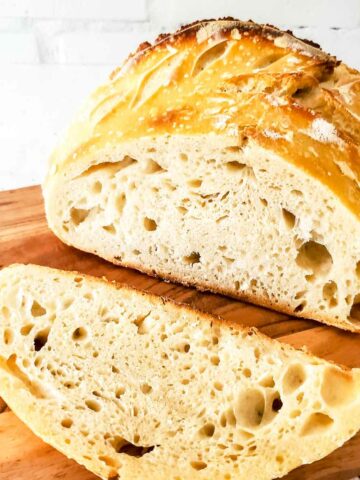 Slice of sourdough bread on a wooden cutting board.