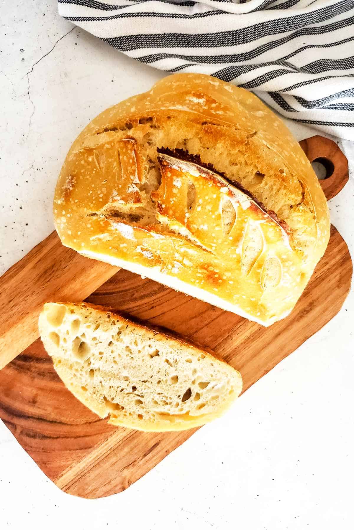 Slice of sourdough bread on a wooden cutting board.