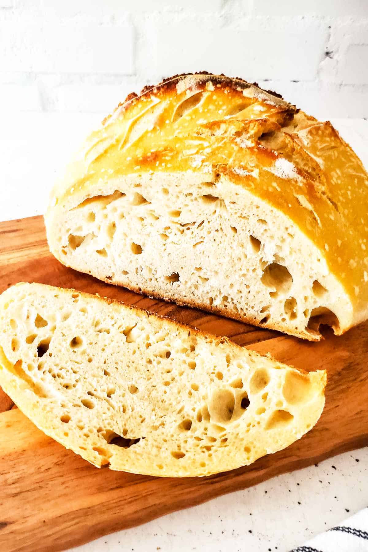 Slice of sourdough bread on a wooden cutting board.