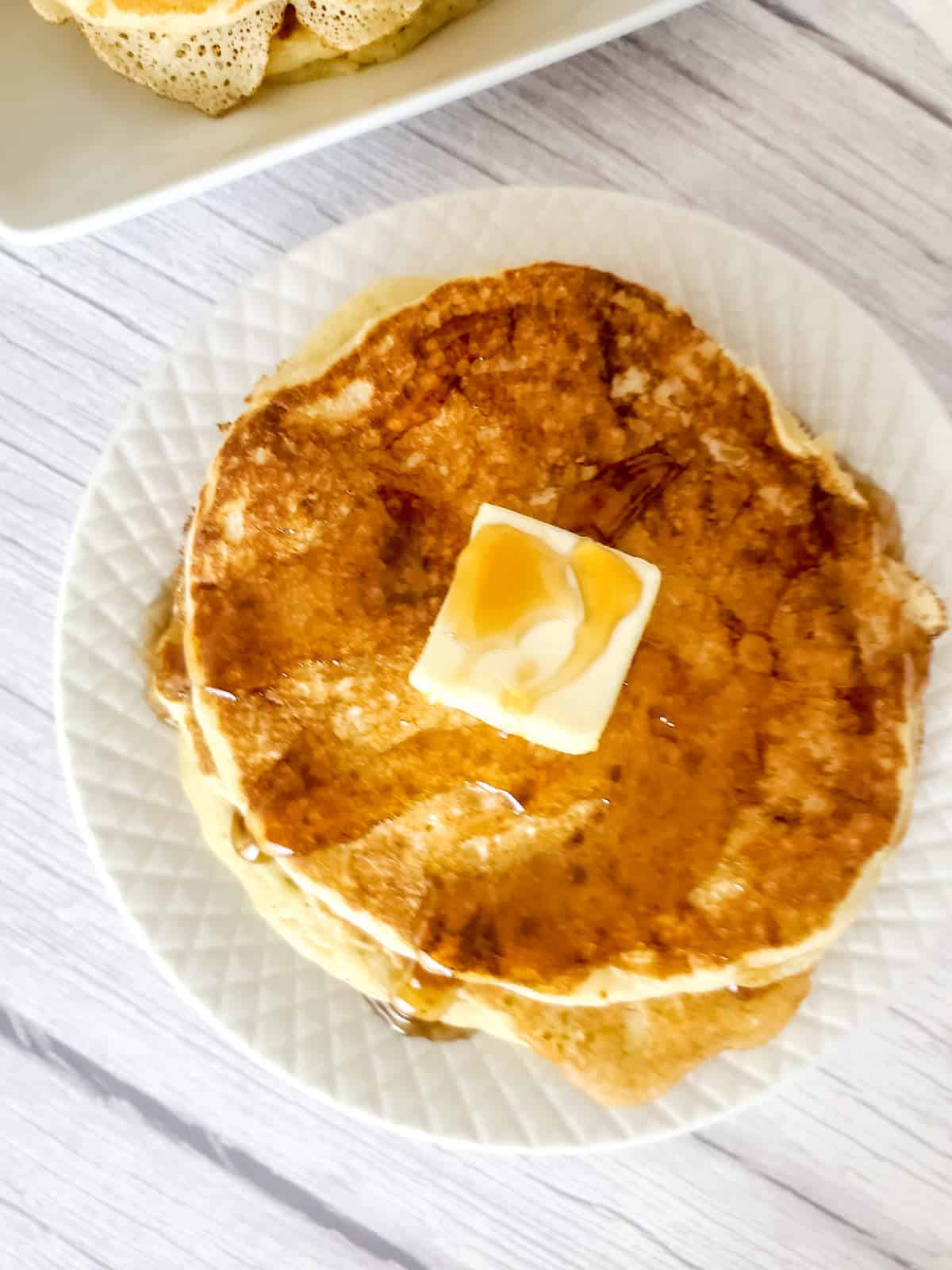 stack of sourdough discard pancakes with butter and syrup.