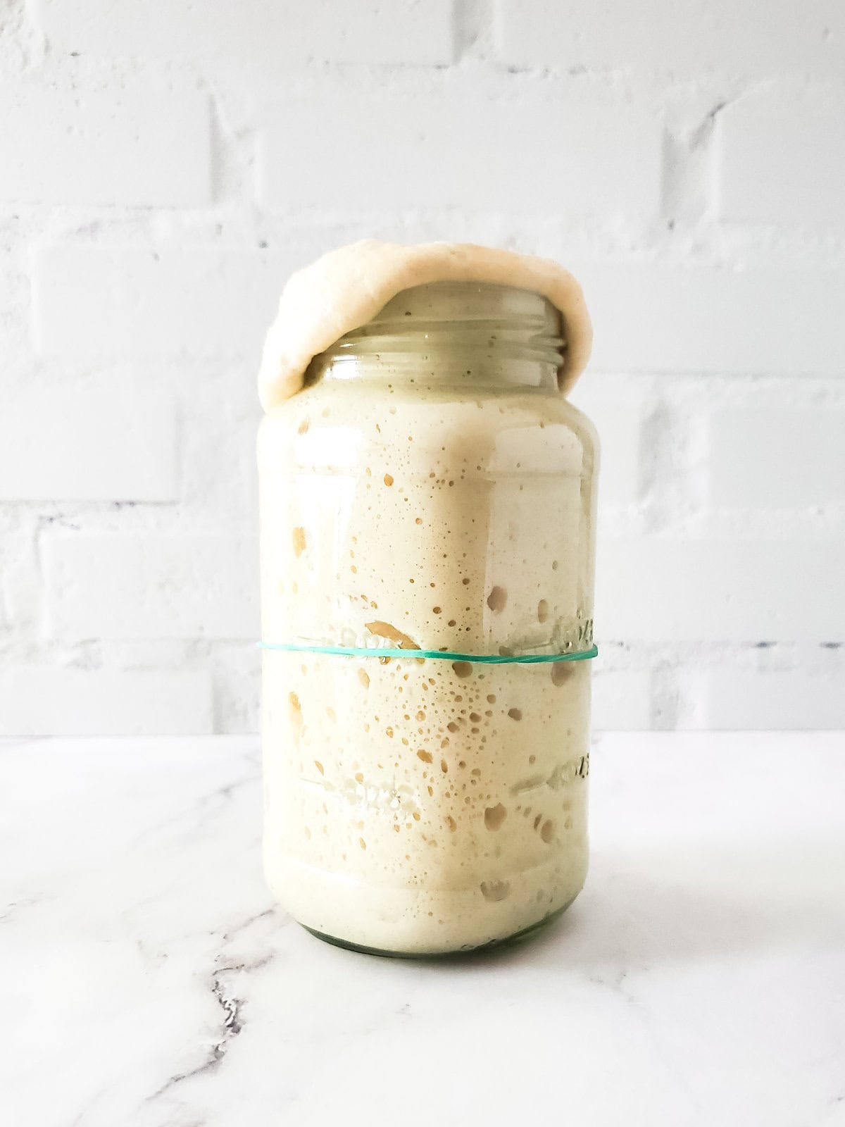 very active sourdough starter overflowing the jar.