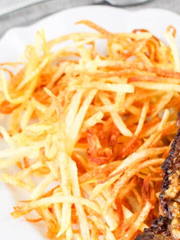 steak frites served on a plate with a seasoned, seared steak.