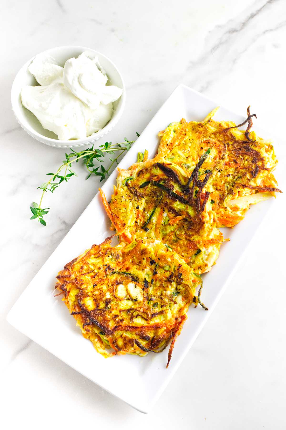 serving platter with zucchini carrot latkes with feta cheese.