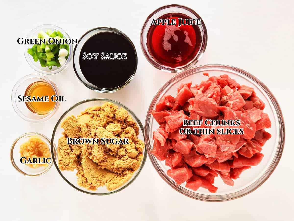 Bowls of ingredients for a broiled Korean Beef Bulgogi marinade, including green onion, soy sauce, apple juice, sesame oil, garlic, brown sugar, and a large bowl of beef slices, all labeled with text.