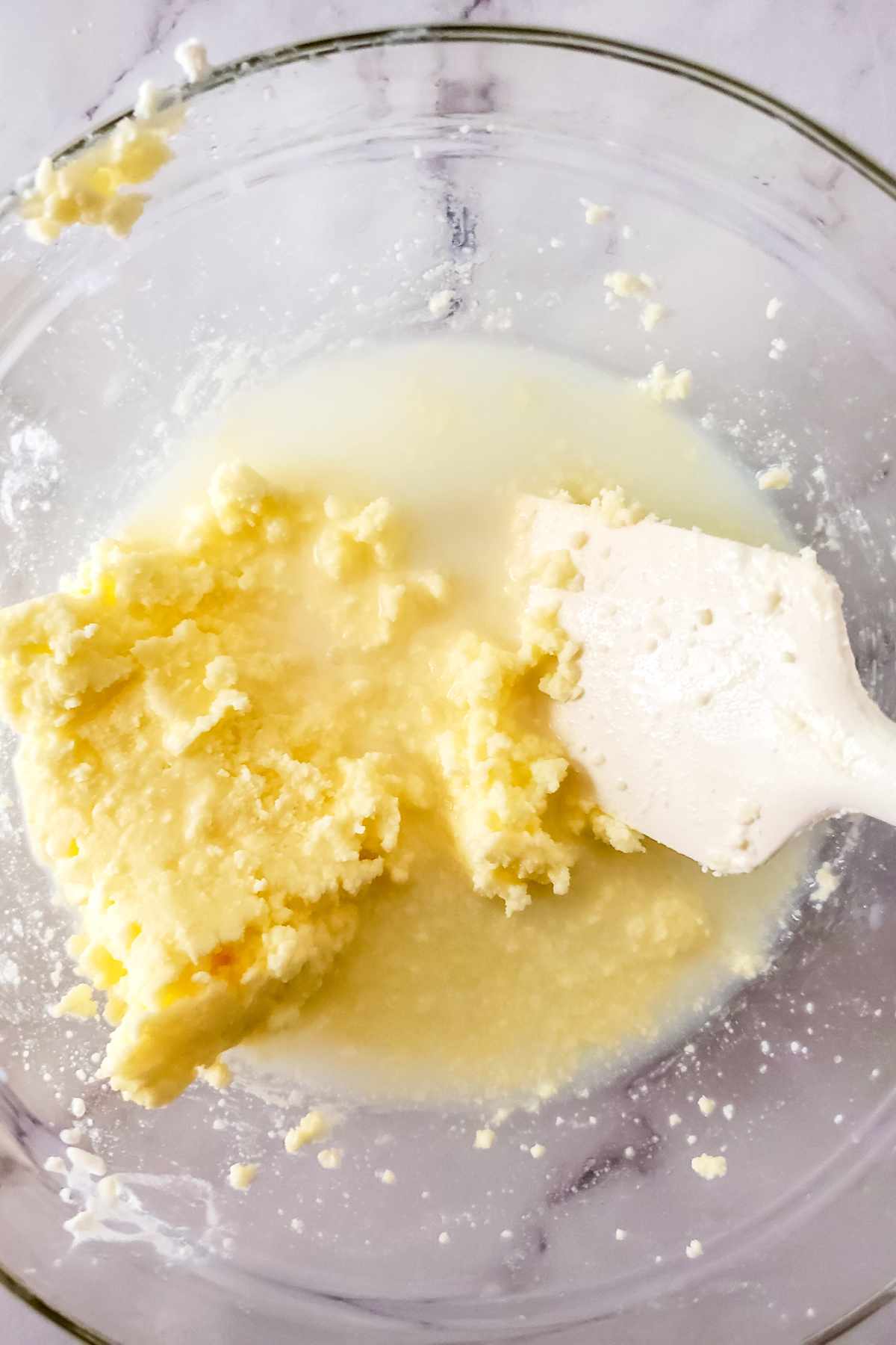 Butter and buttermilk separated in a glass bowl after churning.