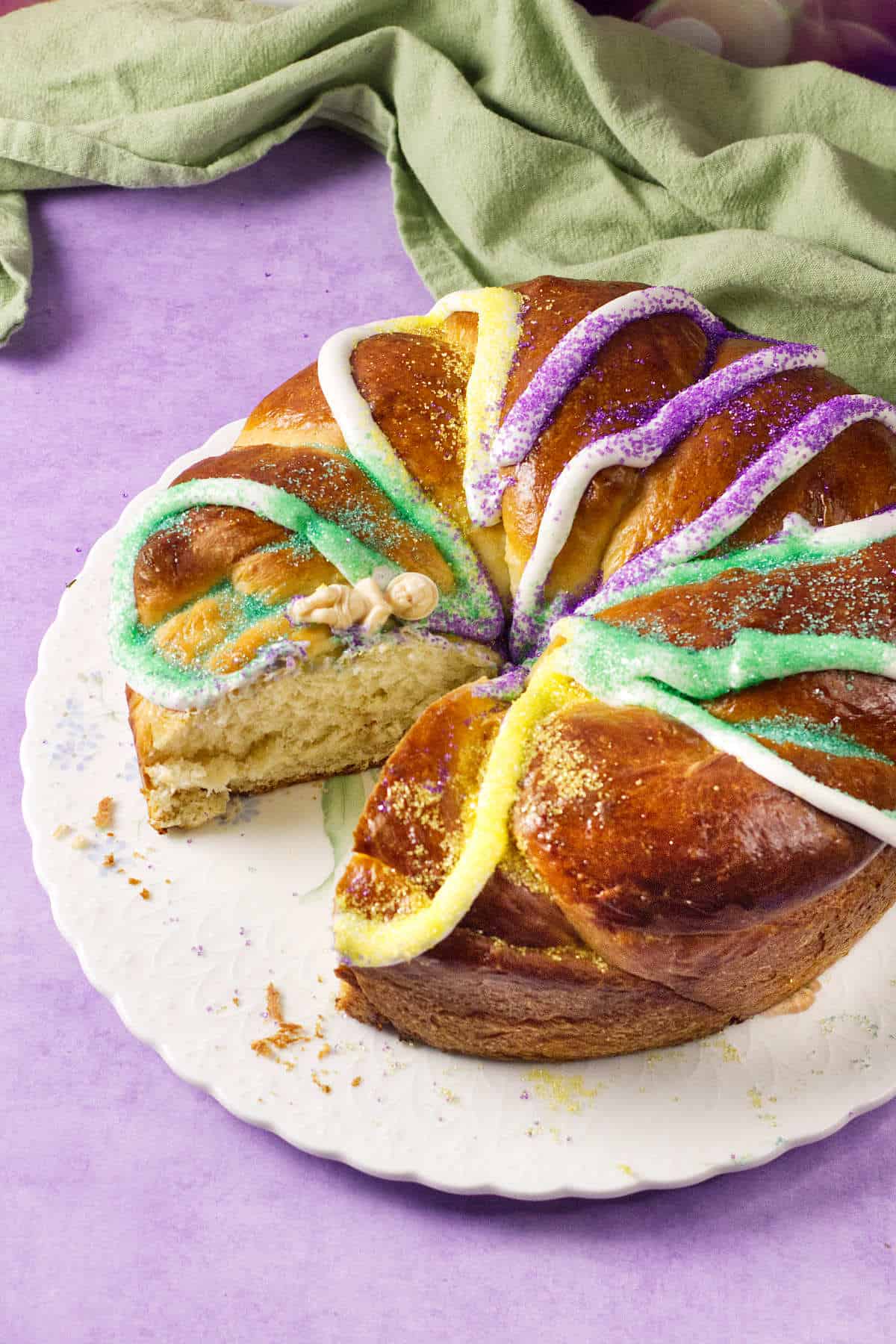 A mardi gras king cake with colorful frosting on it.