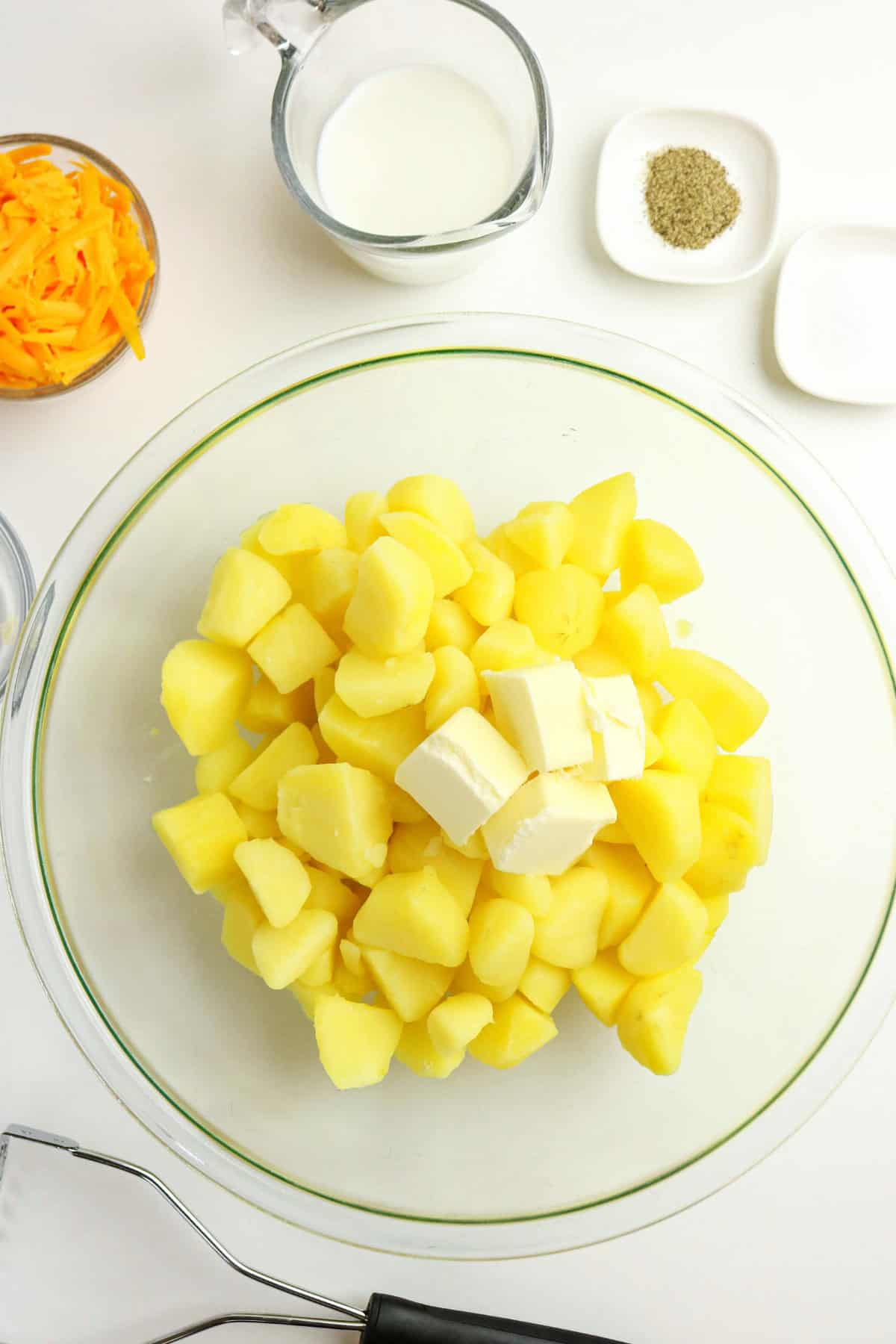 A bowl of mashed potatoes with cheese, topped with creamy butter.