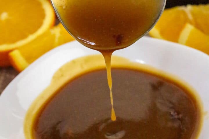 Finished orange teriyaki sauce being poured into a bowl.