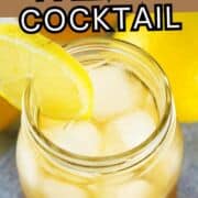 A mason jar filled with iced tea and ice cubes, garnished with a lemon slice on the rim. A whole lemon and another lemon slice are visible in the background.