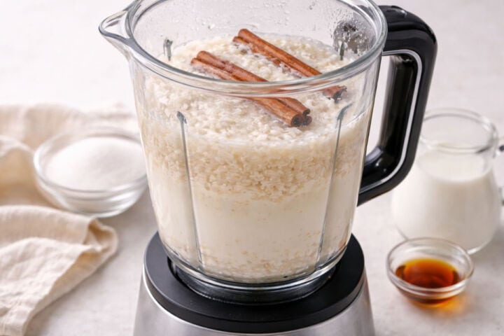 Blender filled with soaked rice cinnamon sticks and water for horchata.