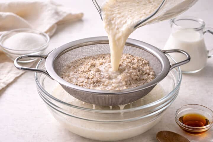 Straining blended rice and cinnamon mixture through a sieve for horchata.