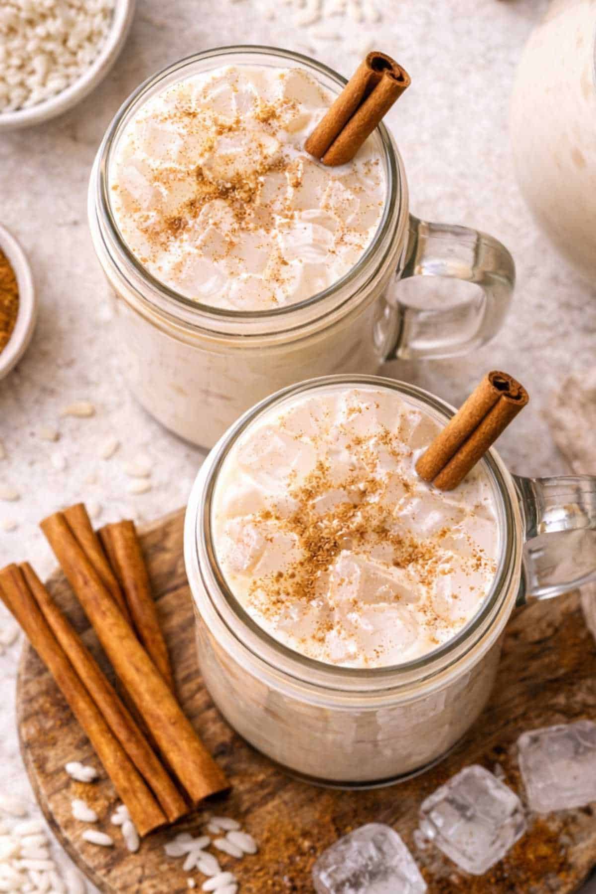 Pitcher and glass of chilled horchata with cinnamon garnish.
