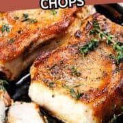 Juicy, pan grilled pork chops on a bone in oil with garlic and herbs in a frying pan.