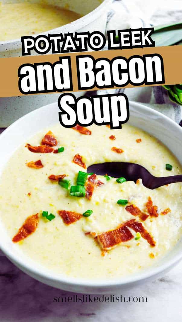 A bowl of creamy potato leek and bacon soup topped with crispy bacon pieces and chopped green onions, with a spoon in the bowl and a pot of soup in the background.