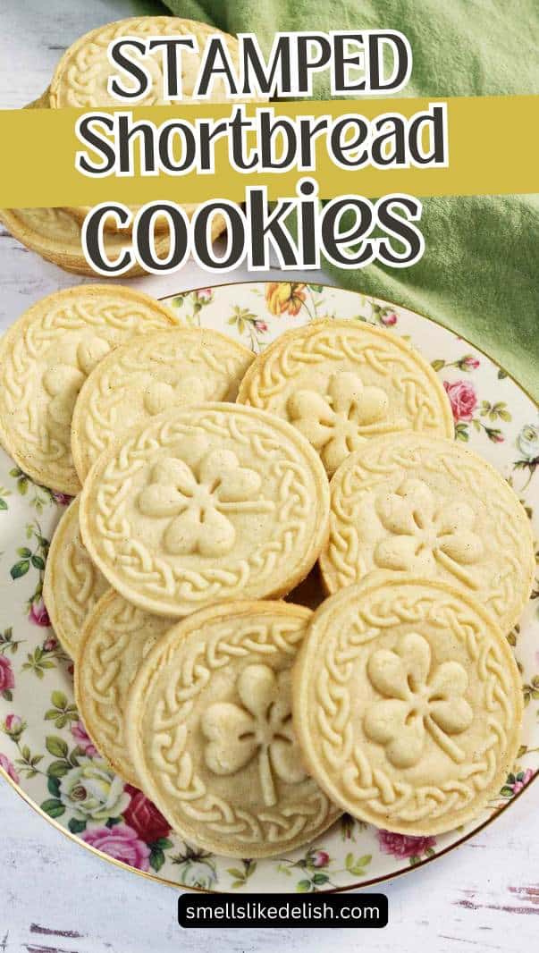 A stack of round, golden stamped shortbread cookies on a decorative plate.
