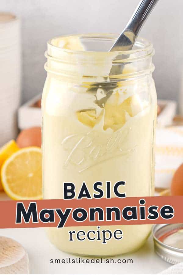 A jar of homemade mayonnaise with a spoon inside, surrounded by lemon halves and eggs on a kitchen counter. Text on the image reads "Basic Mayonnaise Recipe" and "smellslikedelish.com".