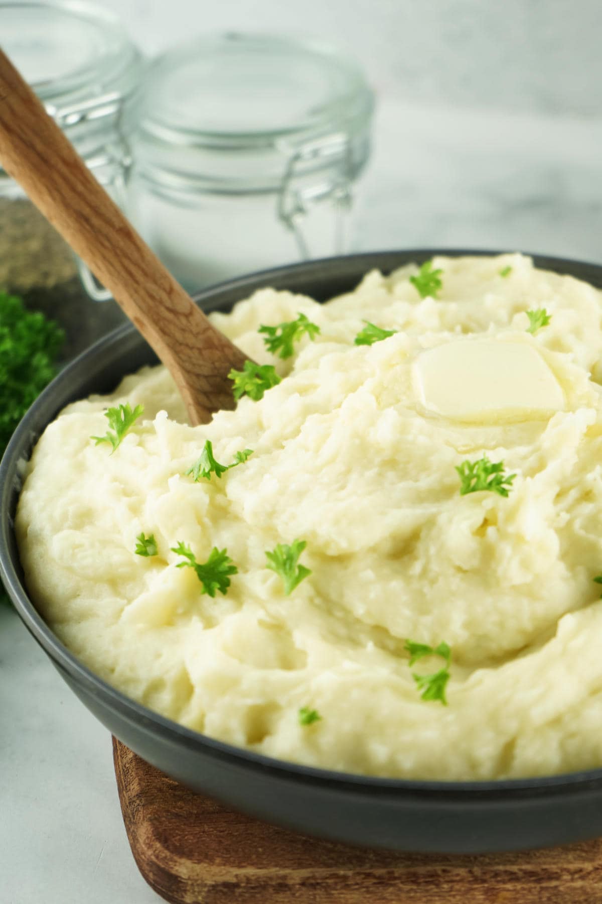 Creamy copycat Bob Evans mashed potatoes in a serving bowl, topped with butter and fresh parsley.