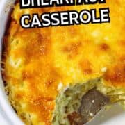 A close-up of a baked green chile breakfast casserole in a white dish, with a serving spoon and a portion scooped out, showing a golden, cheesy top and creamy interior.