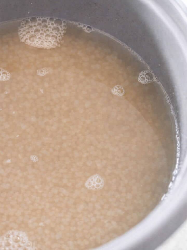 Water added to brown rice in rice cooker pot before cooking.