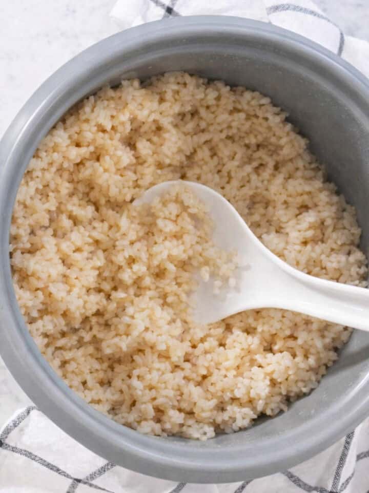 Fluffing cooked short grain brown rice with a rice paddle.