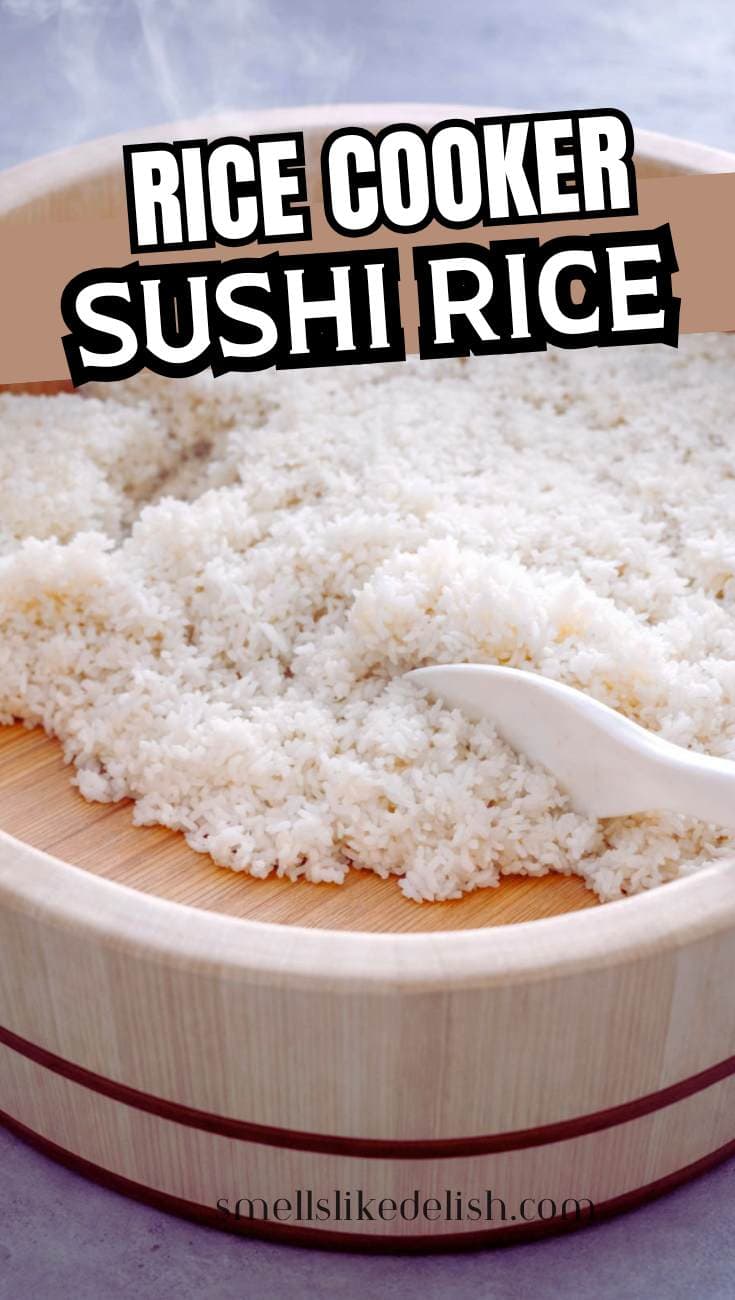 A wooden bowl filled with freshly cooked sushi rice being fluffed with a white spatula. Bold text at the top reads "Rice Cooker Sushi Rice.