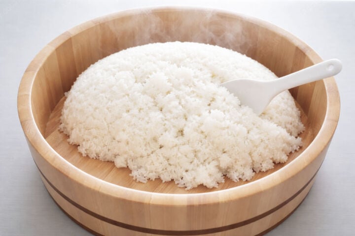 Hot sushi rice turned out into a hangiri to cool.