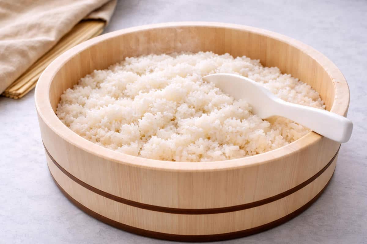 Freshly cooked sushi rice in hangiri with visible steam.